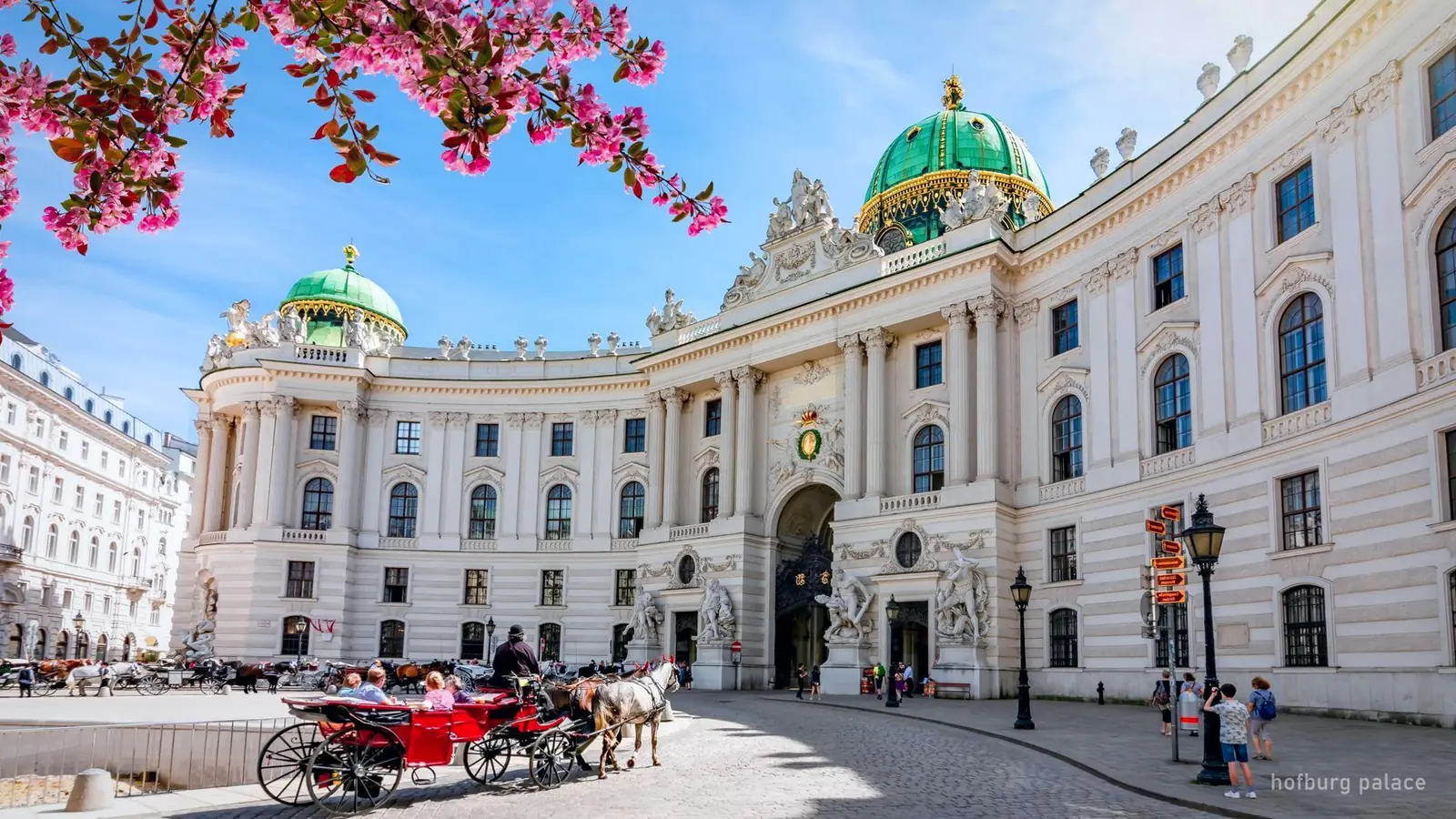 Michaelertor-porten i Hofburg i Wien set over Michaelerplatz om foråret — foto fra bookingsiden