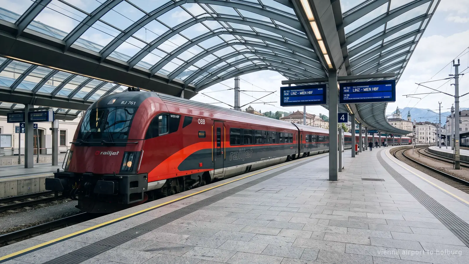 An Austrian intercity train at a station platform under a glass canopy